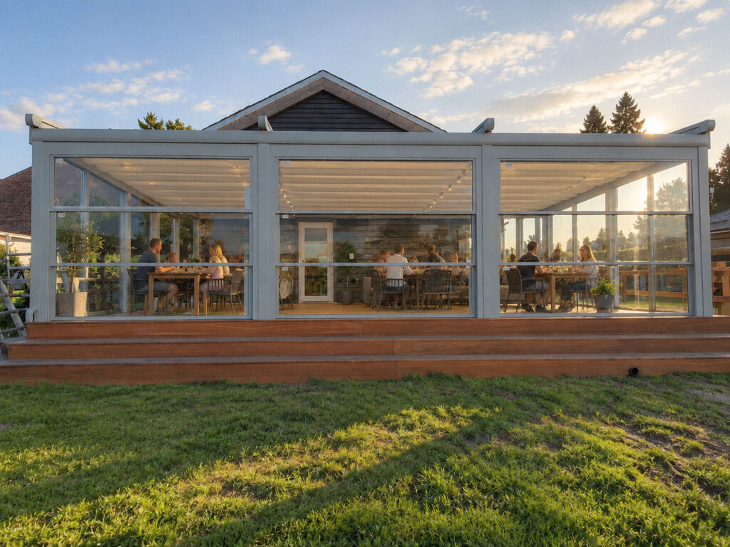 Hvid pergola foran en murstensbygning, set fra græsplænen.
