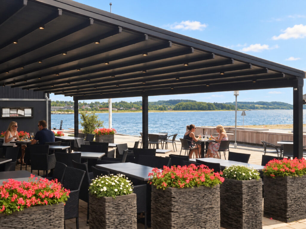 Mørk Ocean-pergola med tilbagetrukket tag på en terrasse ved havnen.