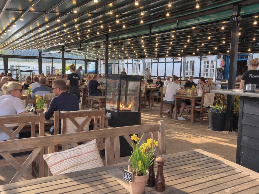 Borde og gæster under den lange terrasseoverdækning hos Futten.